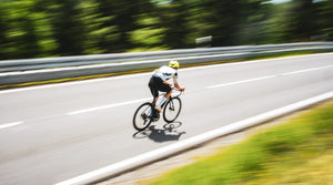 Schneller Radfahrer mit Bewegungsunschärfe auf Straße