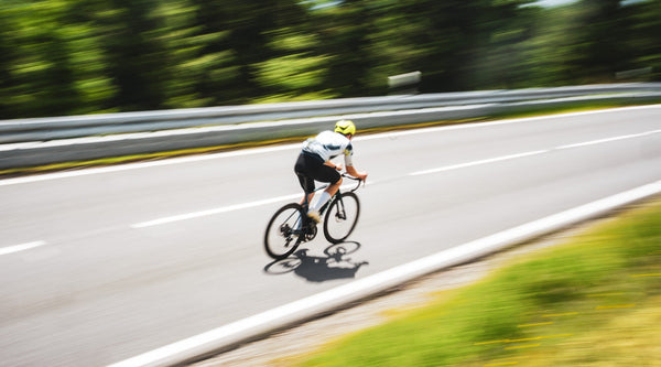 Schneller Radfahrer mit Bewegungsunschärfe auf Straße