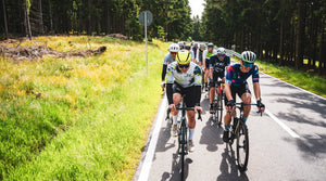 Gruppe von Radfahrern auf Waldstraße in Formation